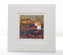 Load image into Gallery viewer, Framed linocut print titled Beneath the Sunset, featuring a vibrant rural landscape with cottages, trees, and flowers in warm orange and deep navy tones beneath a swirling sun.
