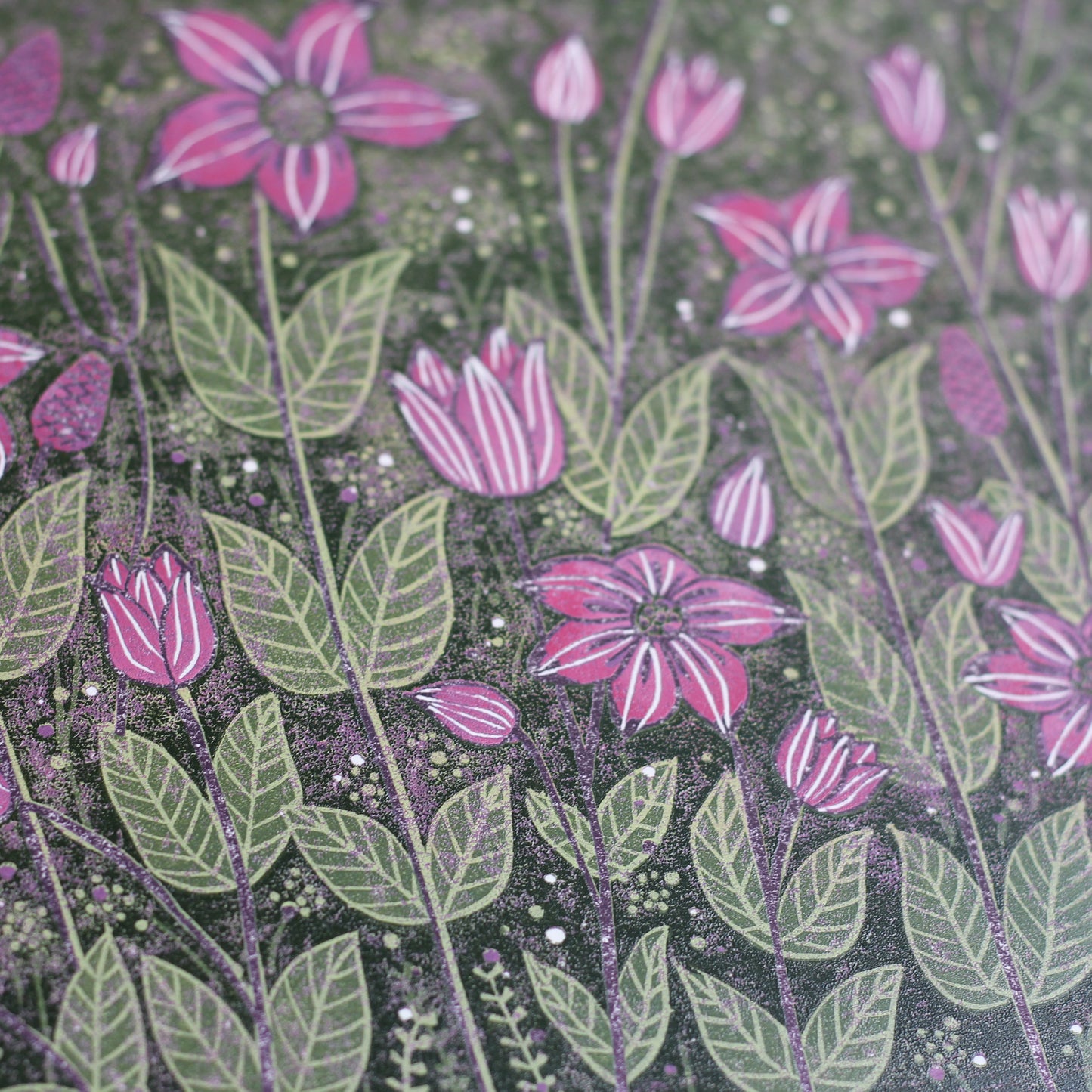 Close-up of the hand-printed purple flowers and rolling fields in the linocut, showing fine detail.