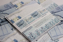 Load image into Gallery viewer, Close-up of the Wintry Wonders Collection Christmas cards pack, displaying four cards with two distinct snowy winter scenes in soft blues, grays, and whites. Each design is featured twice, highlighting the serene snowing effect.