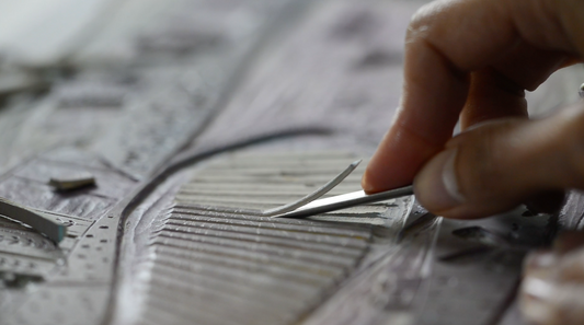 Close-up of Layla Khani carving a lino block for an original reduction linocut print.