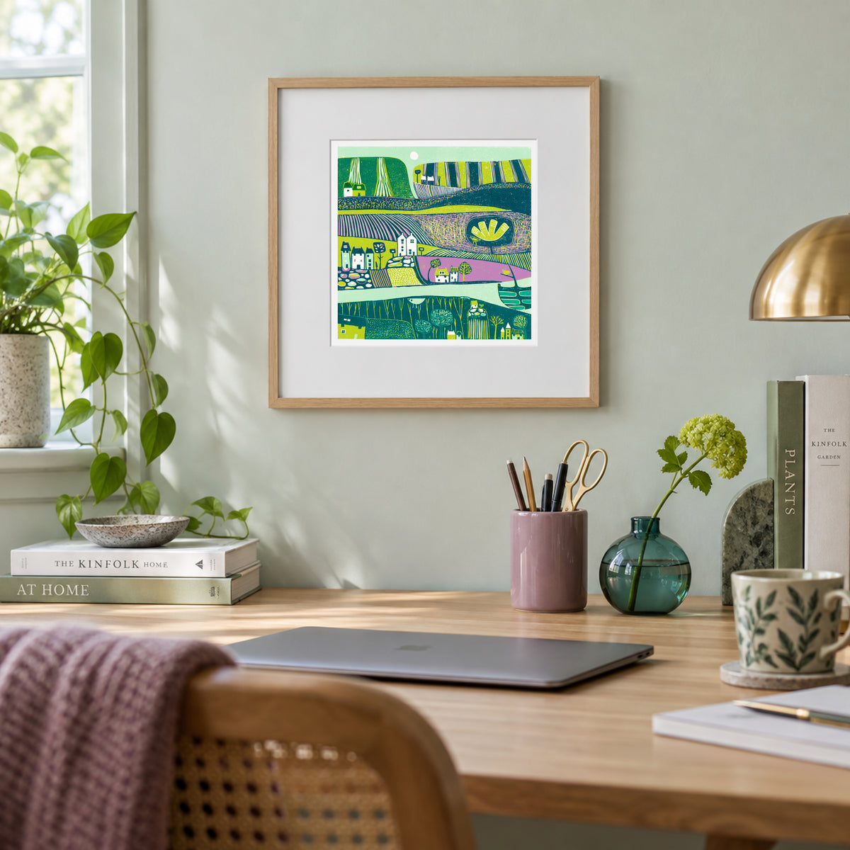 Green Valley framed landscape linocut print displayed above a home workspace