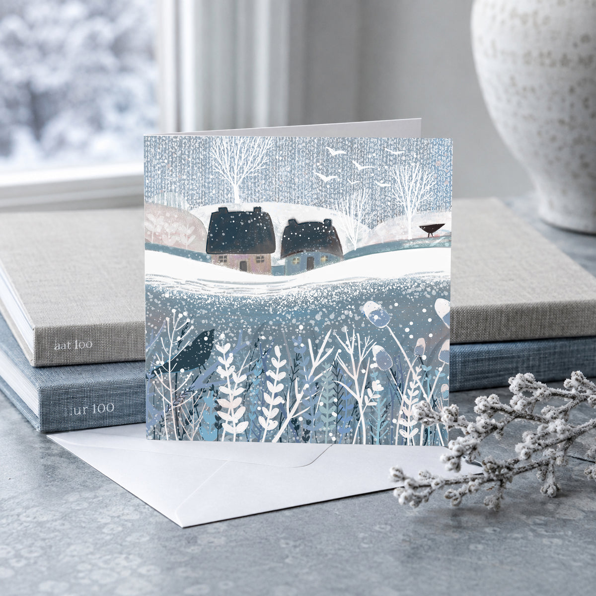 Winter Birds Christmas card displayed with envelope in a festive interior setting