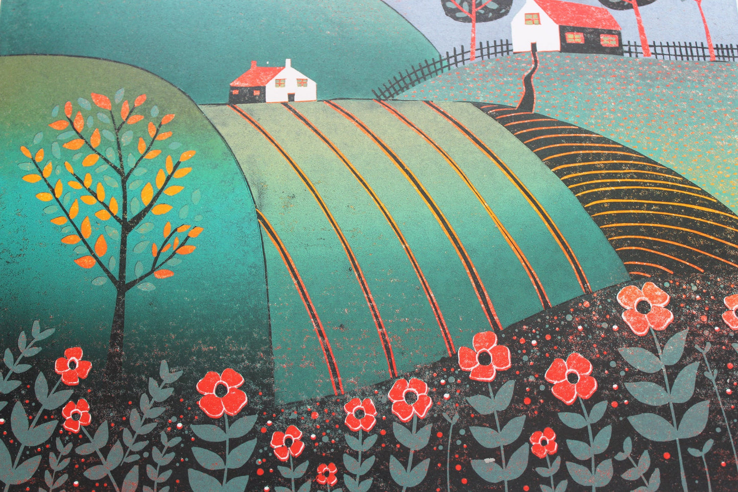 Close-up of The Path Home reduction linocut print showing cottages, rolling green fields, trees and red-orange details.