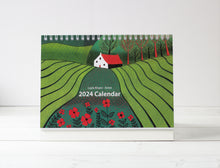 Load image into Gallery viewer, Cover of the 2024 Desktop Calendar, showcasing a captivating landscape with lush greenery and vibrant red flowers in the foreground, masterfully crafted by Laylart Studio.