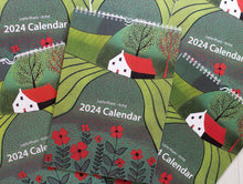 Load image into Gallery viewer, Cover of the A5 Wall Calendar 2024, showcasing a beautiful hand-printed linocut artwork by artist Layla Khani (aka Laylart Studio). The artwork depicts a captivating landscape in vibrant green hues with foreground red flowers.