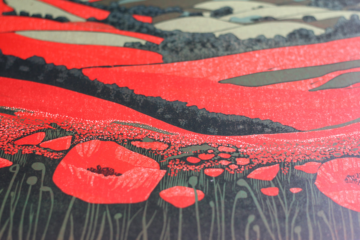 Detail of red poppies, green fields and distant blue hills in an original reduction linocut