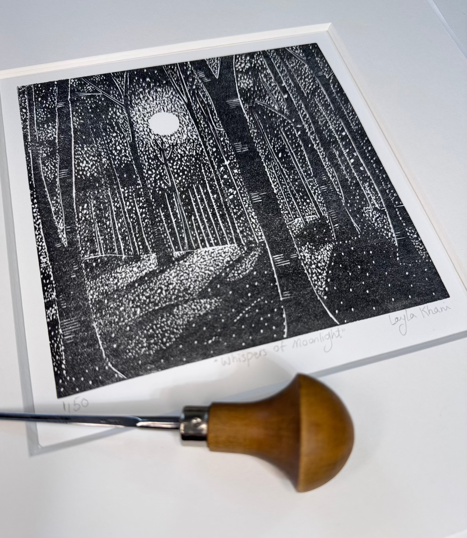Hand-carved detail of Whispers of Moonlight linocut print shown with a lino cutting tool
