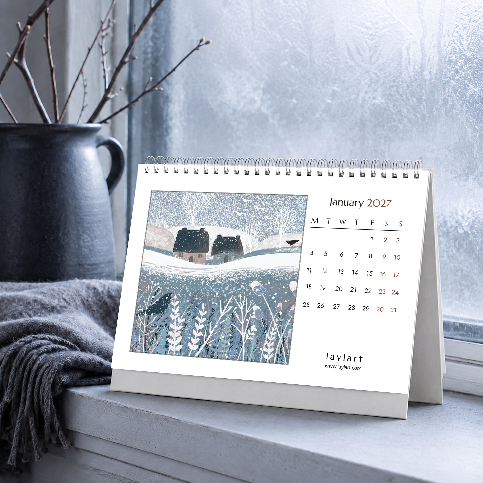 A5 2027 desk calendar open to January with snowy winter countryside artwork