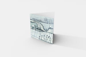 Christmas card from the Wintry Wonders Collection, depicting a snowy winter scene in subtle shades of blue, gray, and white. The linocut print features a gentle snowing effect, perfect for festive greetings.