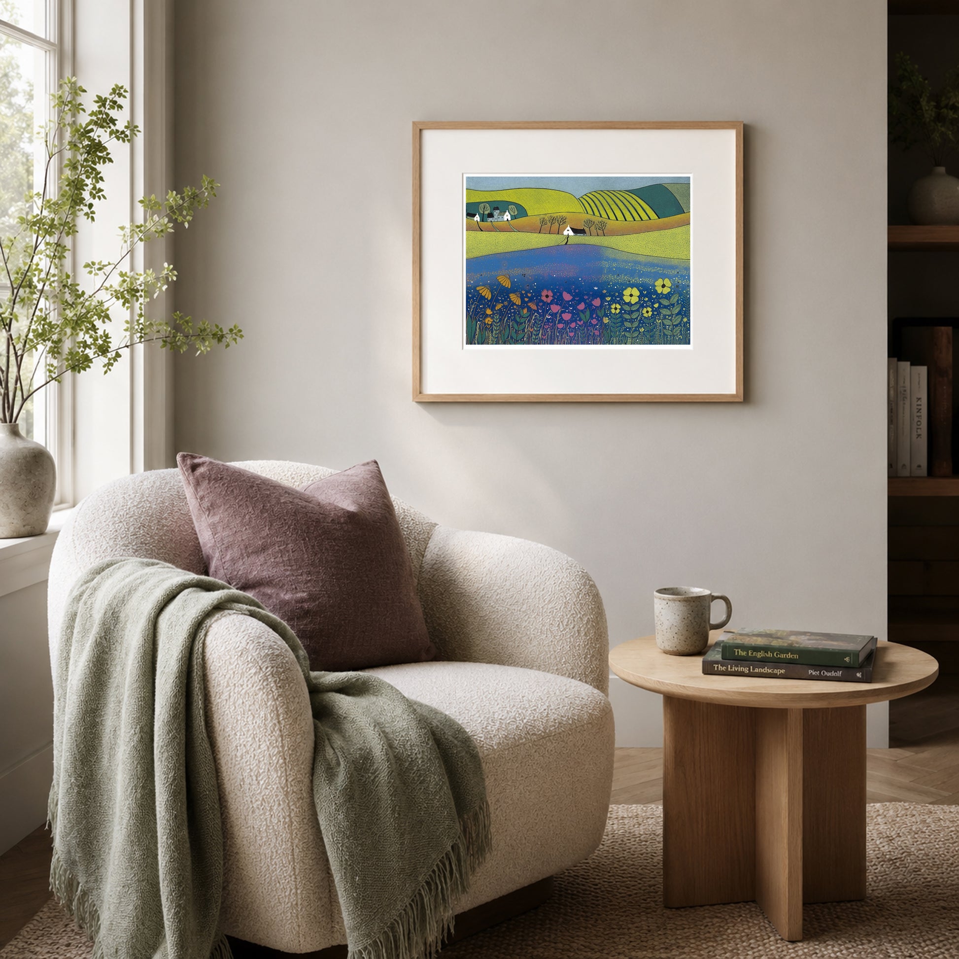 Sea of Tranquility print framed in oak on a lilac-grey wall beside a cream boucle armchair and side table.