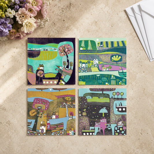 Set of four colourful linocut greeting cards of folk villages, styled with dried flowers and envelopes, by Layla Khani