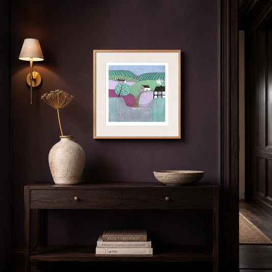 Apple Orchard linocut print framed in oak on a deep aubergine hallway wall above a dark console table.