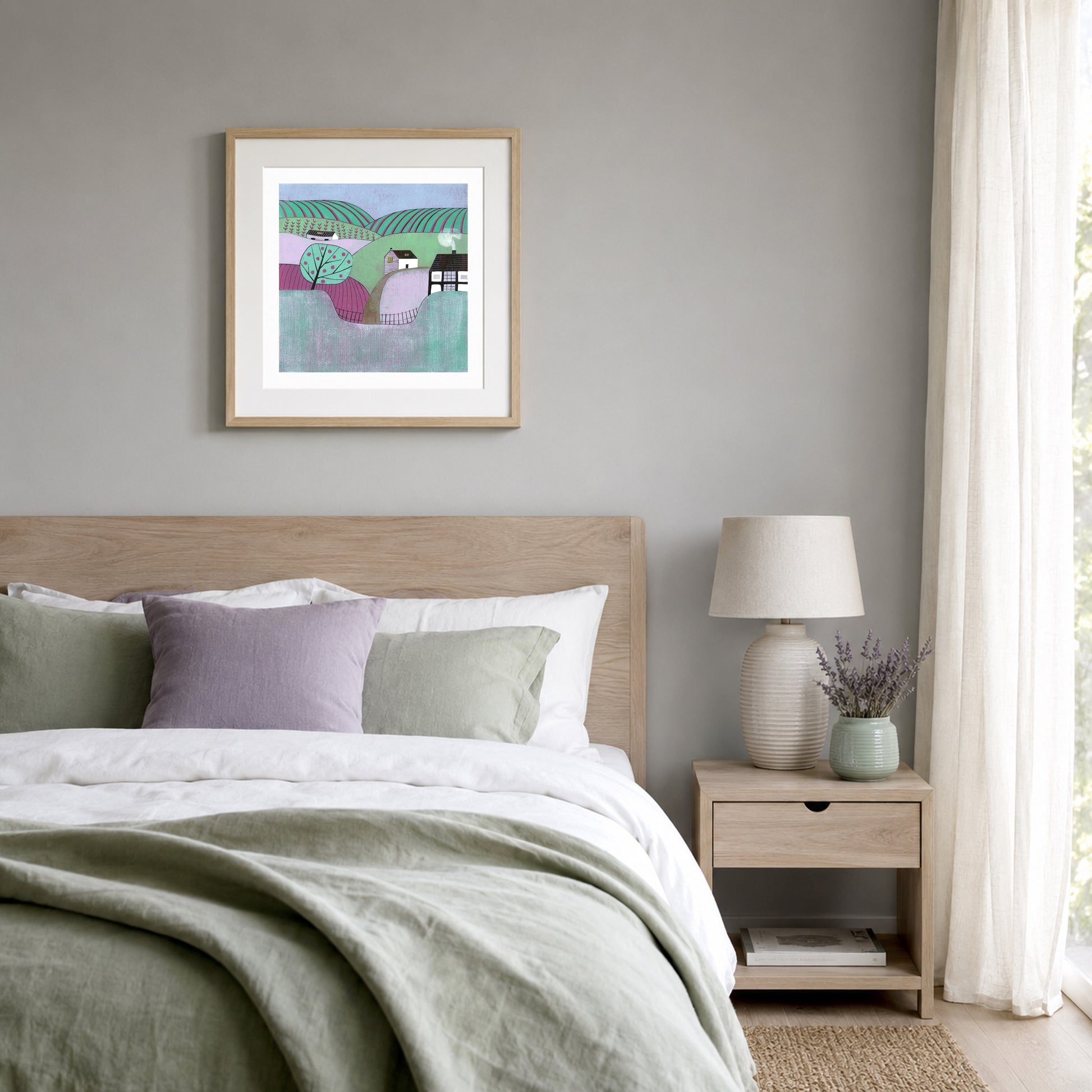 Apple Orchard linocut print in an oak frame above a bed with sage linen and lavender.
