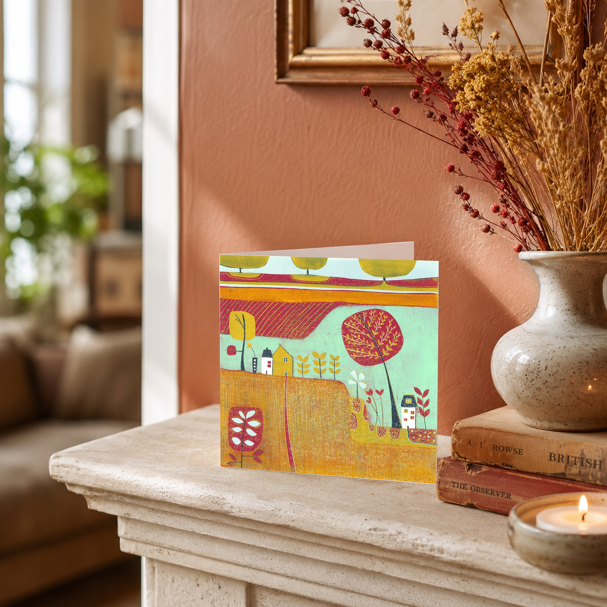 Gentle Caress of Autumn greeting card displayed on a mantelpiece beside a ceramic vase of dried flowers.