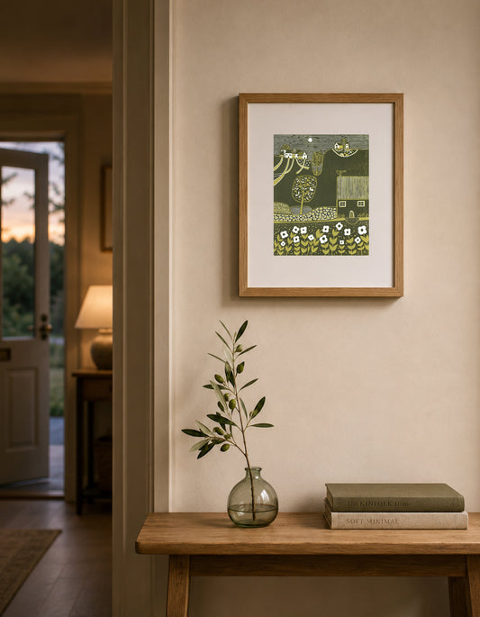 Framed Serene Hillside linocut print displayed above a wooden console table in a warm neutral interior.