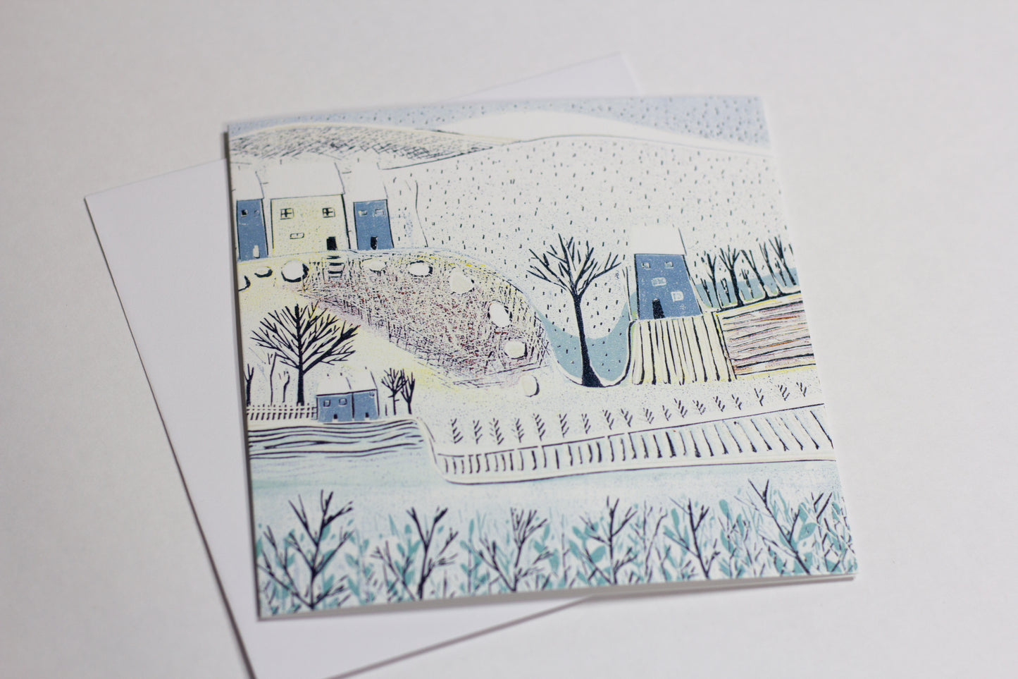 Close-up of a winter landscape Christmas card reproduced from an original linocut print.