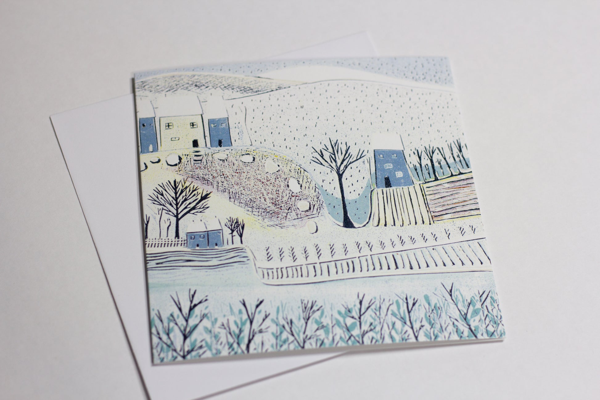 Close-up of a winter landscape Christmas card reproduced from an original linocut print.