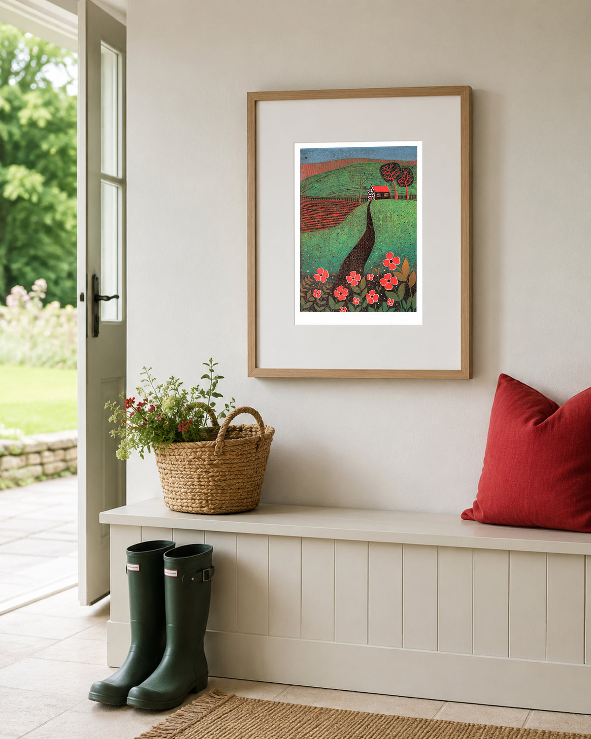 The Red Roofed Cottage original linocut print displayed in a light interior beside a window