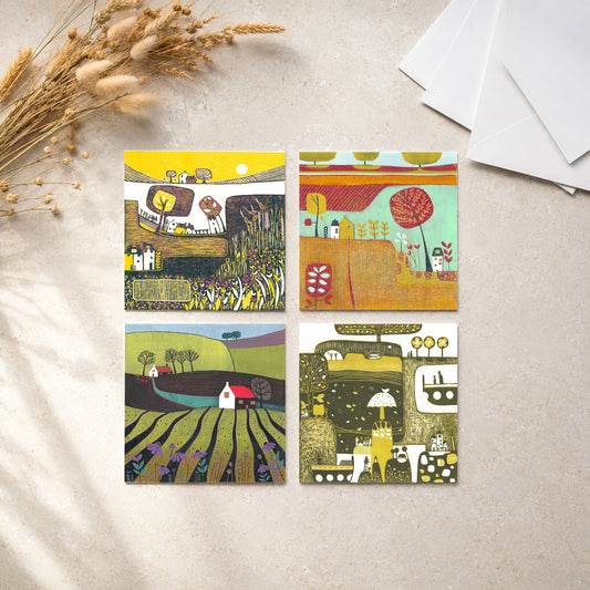 Set of four linocut greeting cards of autumn landscapes, styled with wheat and an envelope, by Layla Khani