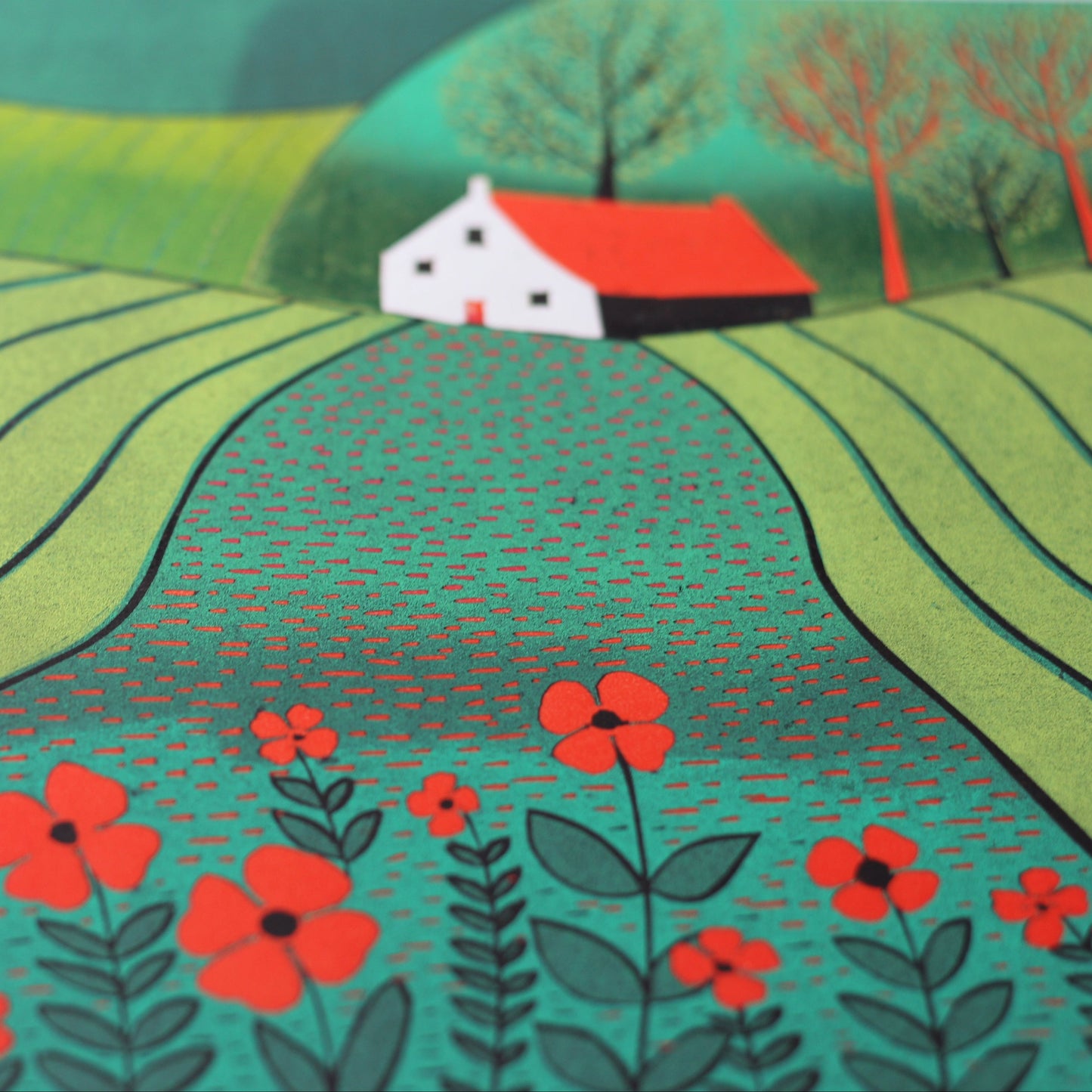 Close-up of the linocut showing the textured green furrows and hand-printed scarlet poppies.