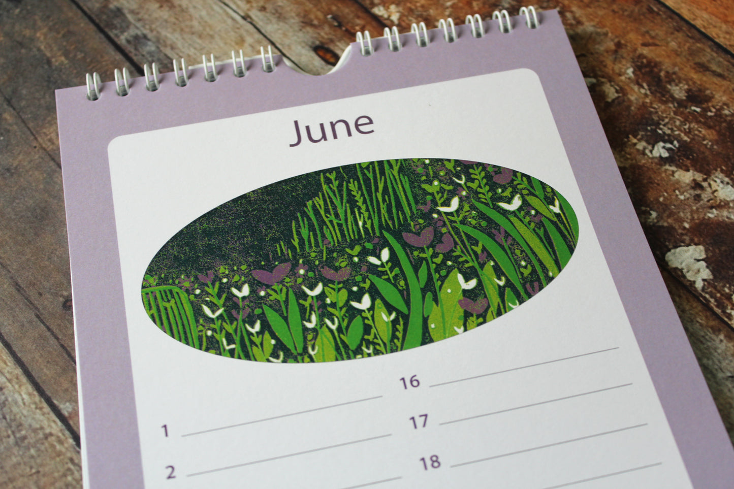Laylart linocut birthday calendar open to June with meadow scene