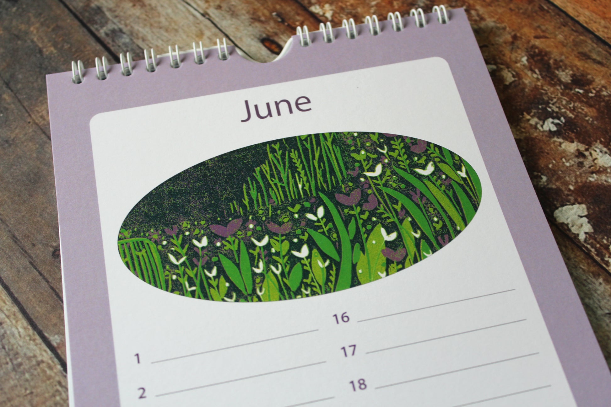 Laylart linocut birthday calendar open to June with meadow scene